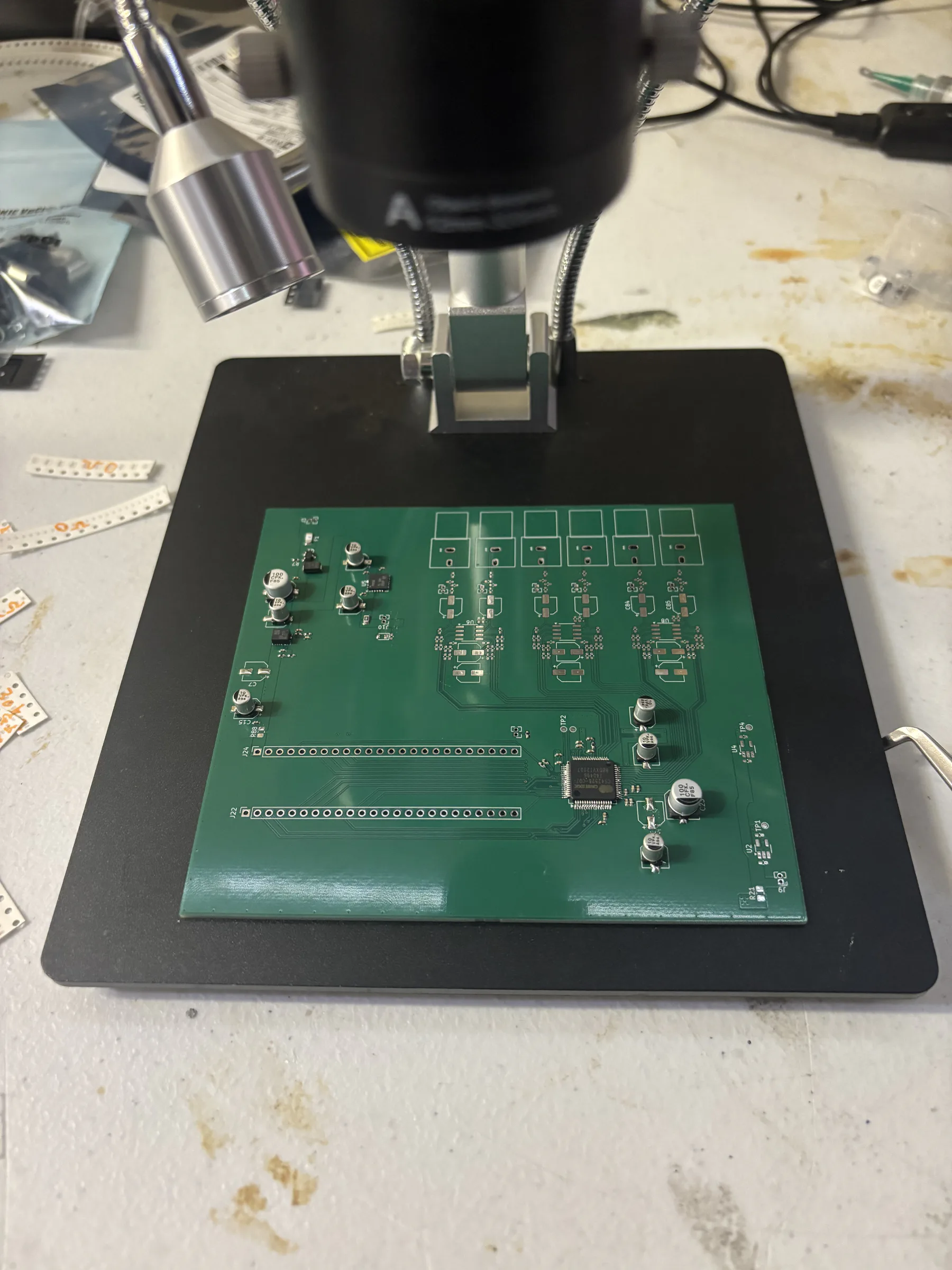 Partially assembled DSP Revision 2 PCB positioned under a digital microscope.