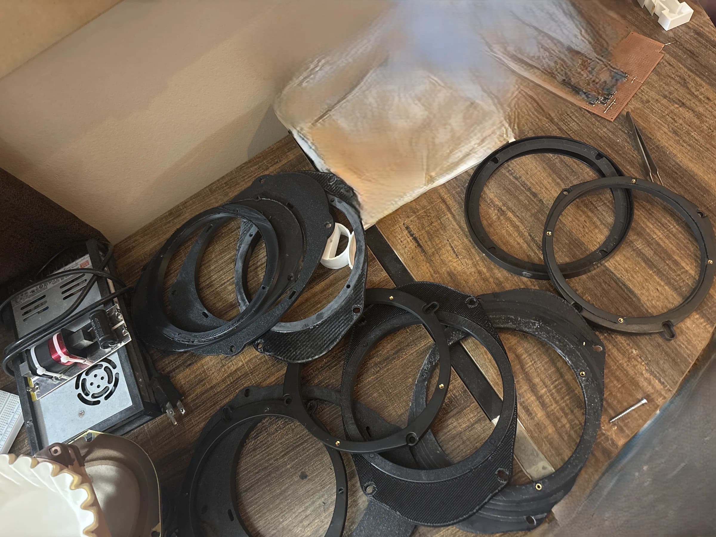 Pile of 3D-printed 6.5-inch speaker adapter revisions from repeated fitment testing.